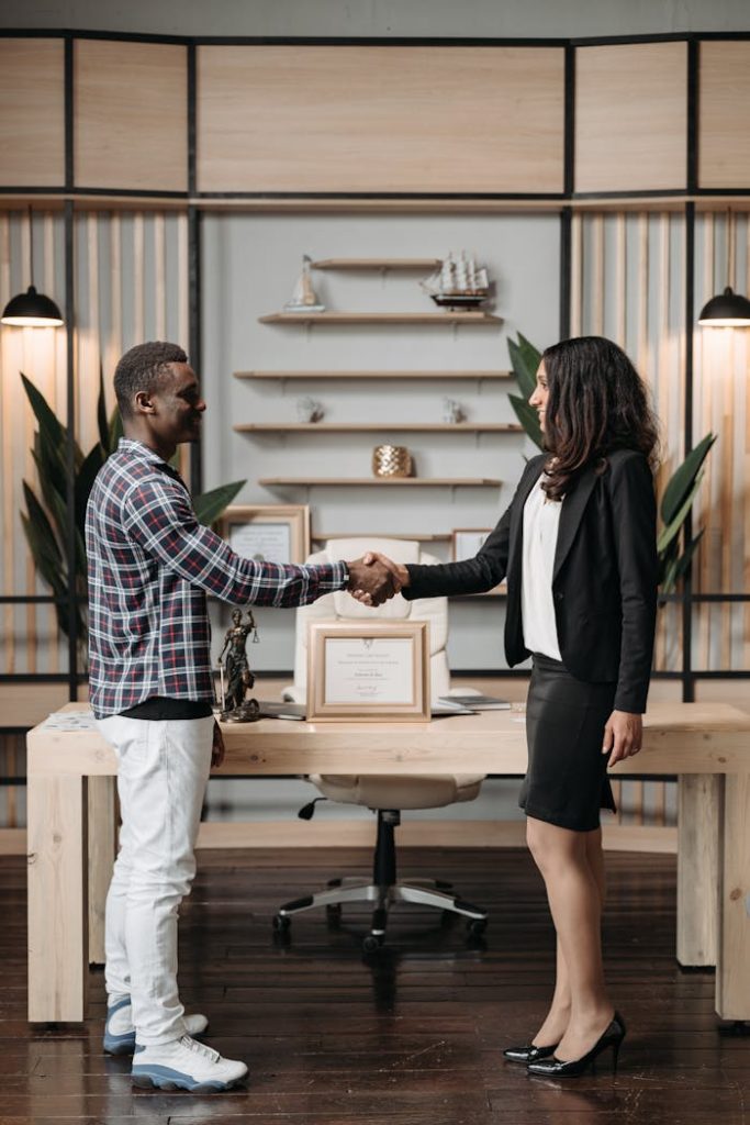 Professional handshake between colleagues in a stylish, modern office setting.